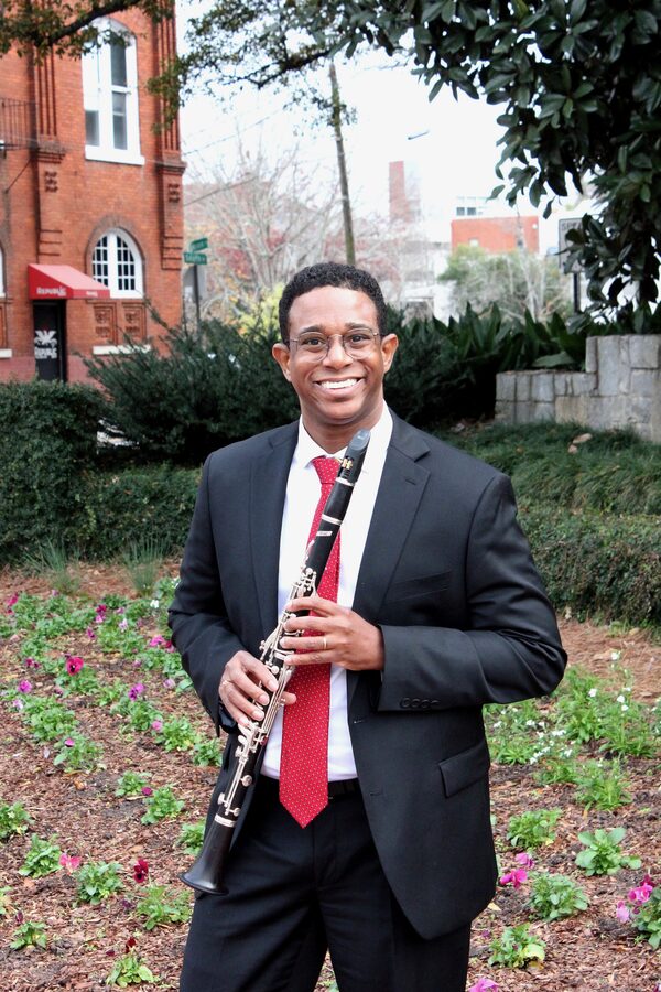 Dr. Ricardo Ferreira holding a clarinet outdoors